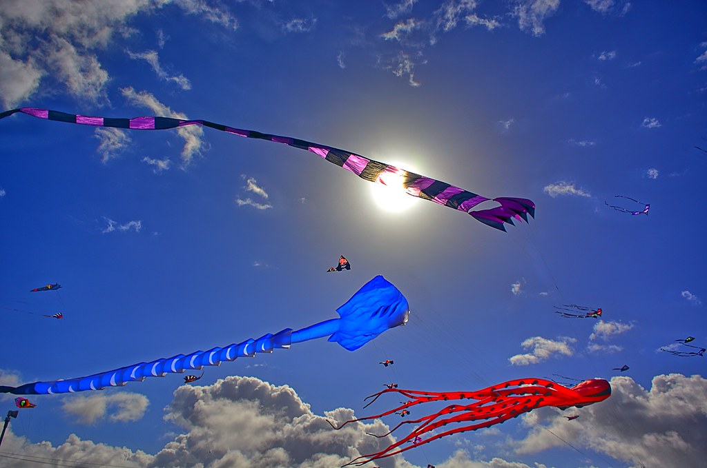 Aquiloni colorati in volo su una spiaggia, come al Jesolo Beach & Kite Festival